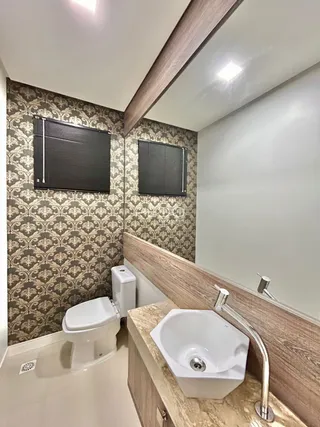 Foto de um banheiro com azulejos e louças sanitárias.