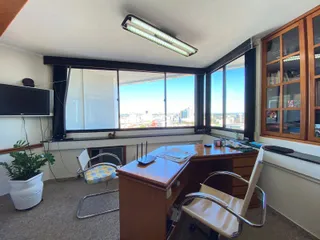 Sala com vista para a cidade através de grandes janelas.