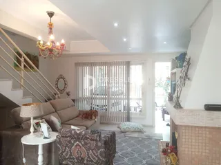 Sala de estar com sofá e escadaria em uma residência.
