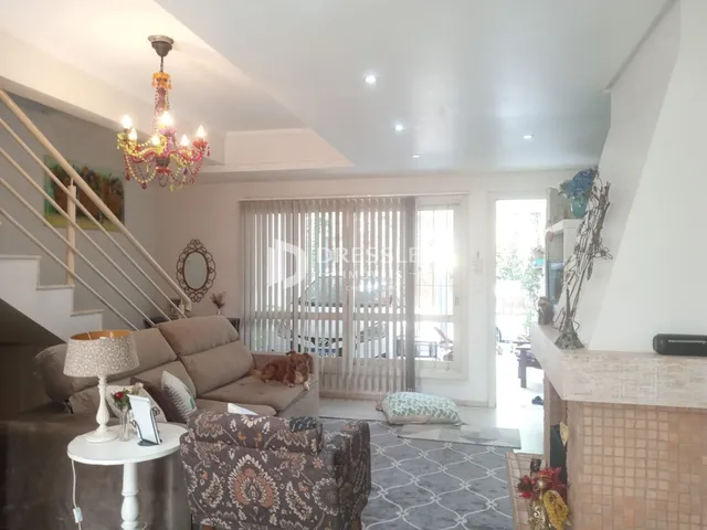 Sala de estar com sofá e escadaria em uma residência.