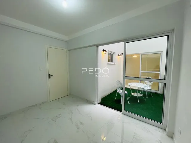 Ambiente interno com piso de mármore e porta branca.