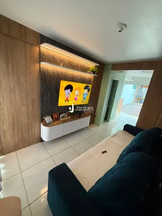 Sala de estar com sofá azul e piso de cerâmica em um imóvel no Brasil.