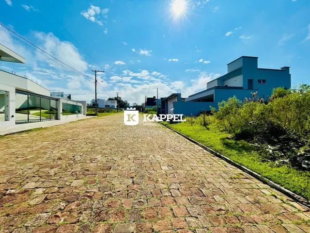 Vista externa de uma residência moderna com paisagismo sob um céu claro.
