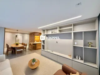 Uma sala de estar ampla com decoração moderna e estantes embutidas.