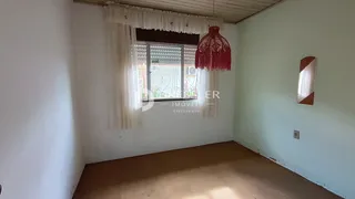 Foto de um ambiente interno com paredes brancas e uma janela.