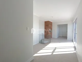 Hall de entrada com paredes brancas e piso claro.