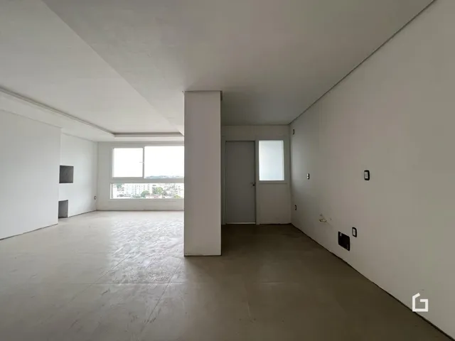 Ambiente interno amplo com paredes brancas e piso de concreto.