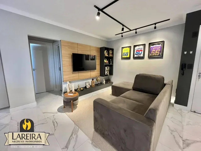 Sala de estar moderna com sofá e painel de madeira em um imóvel no Brasil.