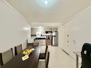 Foto de uma sala de jantar com uma cozinha ao fundo.