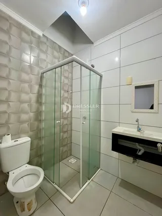 Foto de um banheiro com box de vidro e vaso sanitário em Lajeado.