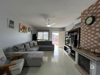 Sala de estar com sofá e piso de cerâmica em uma residência.