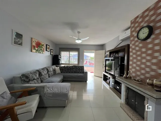Sala de estar com sofá e piso de cerâmica em uma residência.