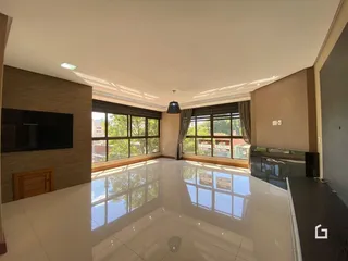 Sala de estar com piso branco e grandes janelas.