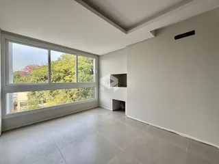 Uma sala de estar ampla com grandes janelas que oferecem uma vista para a vegetação.