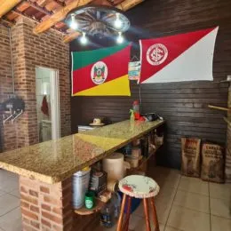 Foto de uma área de cozinha com parede de tijolos aparentes e bancada de granito.