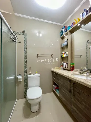 Foto de um banheiro com revestimento cerâmico nas paredes e piso claro.