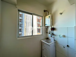 Vista de uma janela mostrando uma parede branca e um sistema de aquecimento em um cômodo.