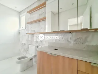 Banheiro moderno com revestimento em mármore e bancada de madeira.