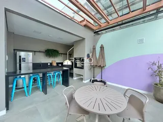 Sala de estar com bancada e mesa de jantar em um apartamento.