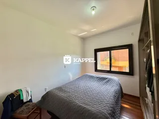 Quarto com cama e janela mostrando o interior da residência.