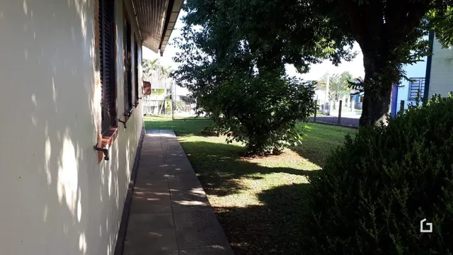 Vista da fachada de uma residência com jardim e gramado.