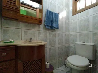 Foto de um banheiro com azulejos brancos.
