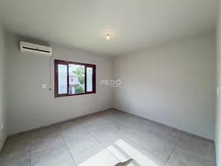 Ambiente interno de uma sala com piso de cerâmica e janela.