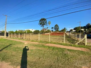 Vista externa do terreno com grama e cerca de arame.