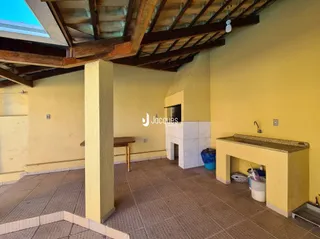 Interior de uma sala com teto de madeira e coluna no ambiente.