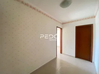 Parede branca de uma área interna é visível na foto.