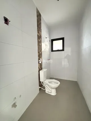 Foto de um banheiro interno com revestimento de cerâmica branca.