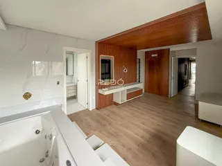Interior de uma sala com piso de madeira e detalhes em mármore.