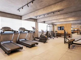 Ambiente de academia moderno com equipamentos de ginástica e piso de concreto.