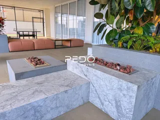 Uma área externa com bancos de pedra no imóvel.