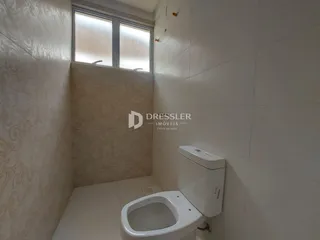Foto de um banheiro com revestimento cerâmico e janela.