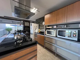Cozinha moderna com armários de madeira e bancada escura.