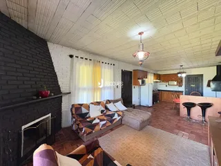 Sala de estar com parede de tijolos expostos e sofá.