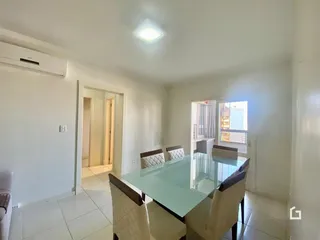 Foto de uma sala de jantar com mesa de vidro e cadeiras em um imóvel.