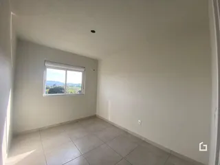 Vista interna de um cômodo com janela para a paisagem.