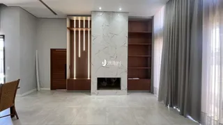 Sala de estar com parede de mármore e lareira em um imóvel no Brasil.