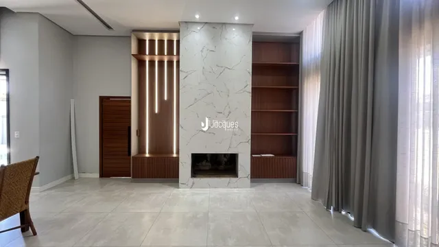 Sala de estar com parede de mármore e lareira em um imóvel no Brasil.