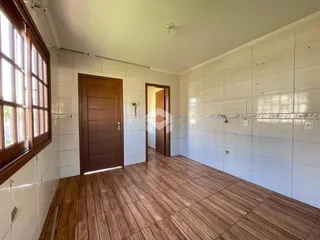 Hall de entrada com piso de madeira e paredes brancas.