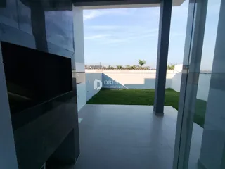 Vista de um ambiente interno com grandes janelas que se abrem para um jardim.