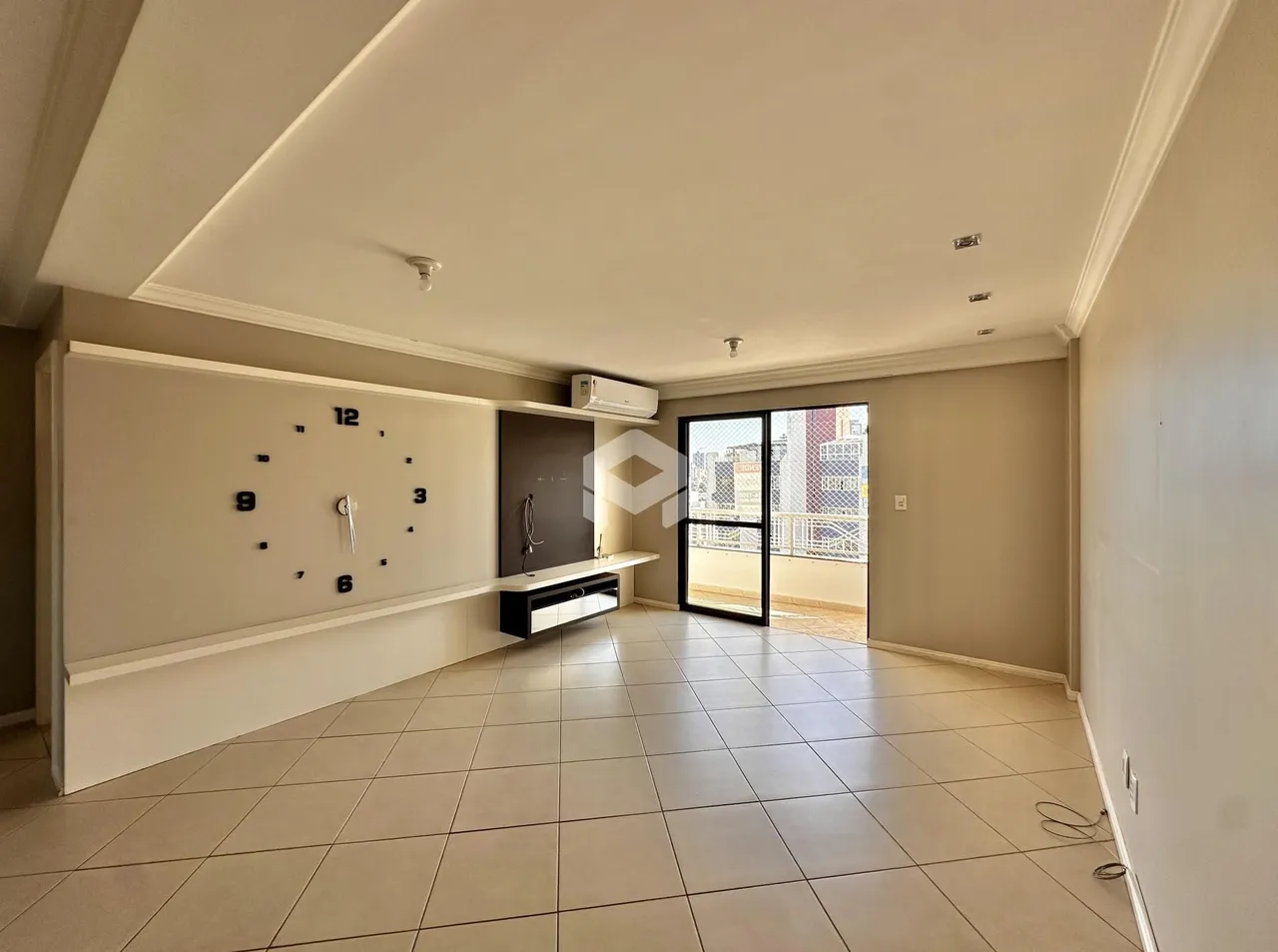 Ambiente interno de uma sala com piso de cerâmica e parede decorativa.
