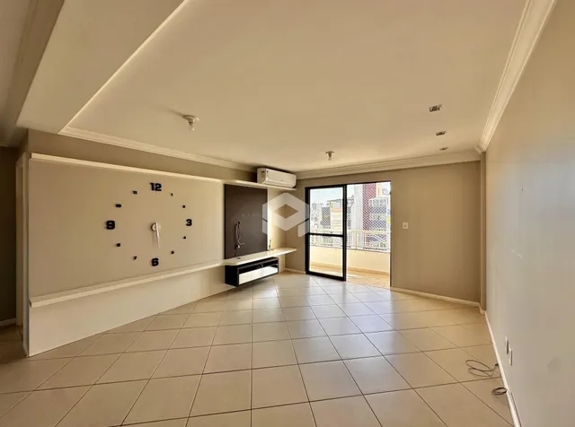 Ambiente interno de uma sala com piso de cerâmica e parede decorativa.