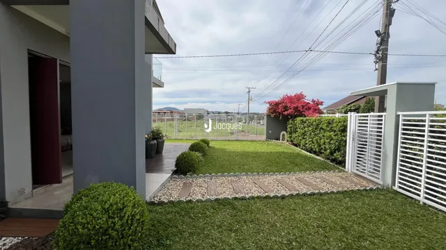 Vista externa de uma residência com jardim e cerca no Brasil.