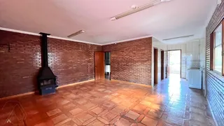 Sala ampla com paredes de tijolo aparente e piso de terracota.