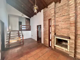 Interior de um ambiente com paredes de tijolo aparente e teto de madeira.