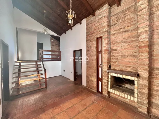 Interior de um ambiente com paredes de tijolo aparente e teto de madeira.