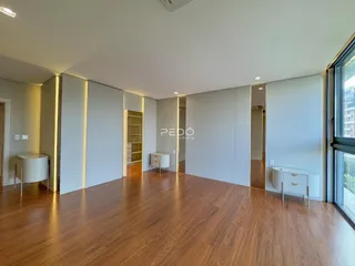 Sala de estar com piso de madeira e armários embutidos.